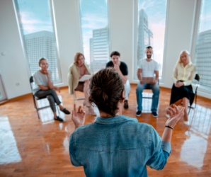 Person giving talk on workplace wellness in an office to business casual dressed employees