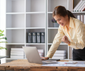 Woman celebrating news read on a laptop