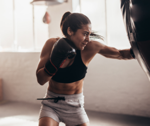 Woman punching bag in gym, boxing