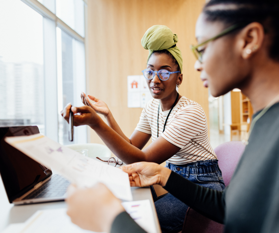 Two women in an office discussing health programs to boost employee morale