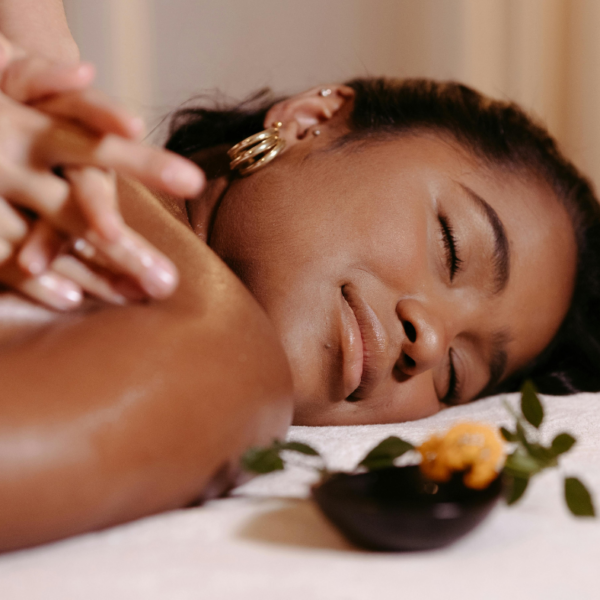 Woman relaxing with eyes closed during a deep tissue massage, illustrating the stress relief benefits of the technique.