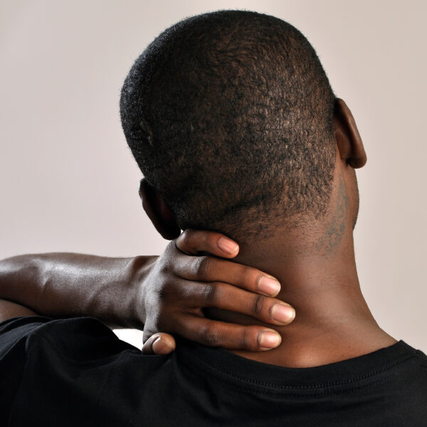 Back view of a man holding his neck due to discomfort or stiffness